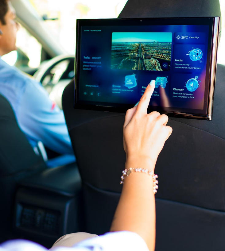 Passenger interacting with an RTA in-taxi interactive screen in Dubai
